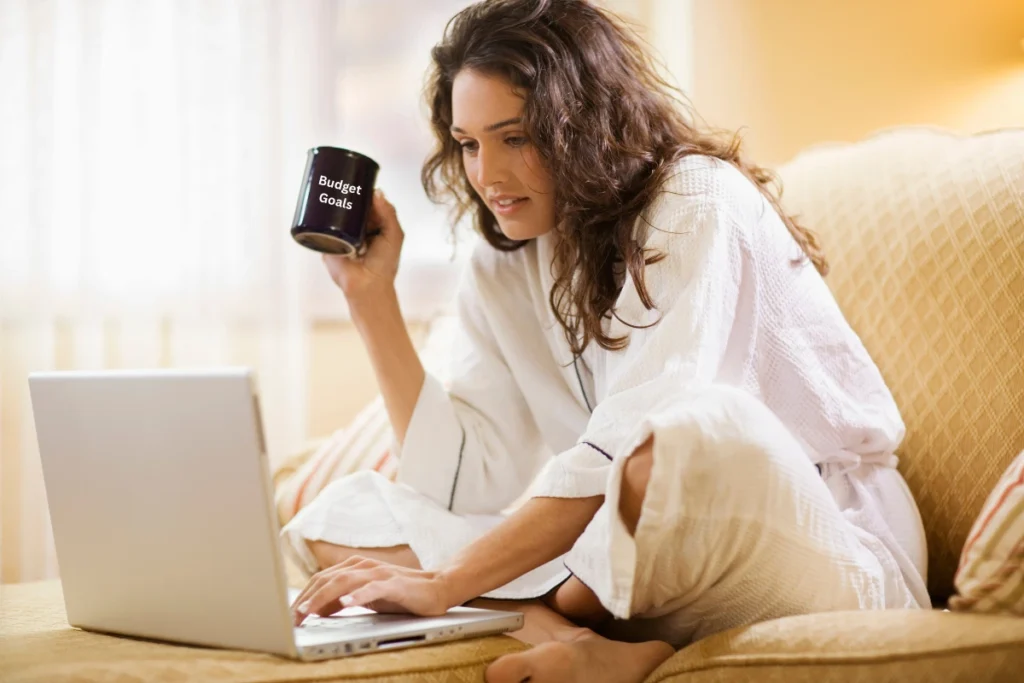 Budget Goals Woman relaxing on a couch with a laptop and a coffee mug that says Budget Goals