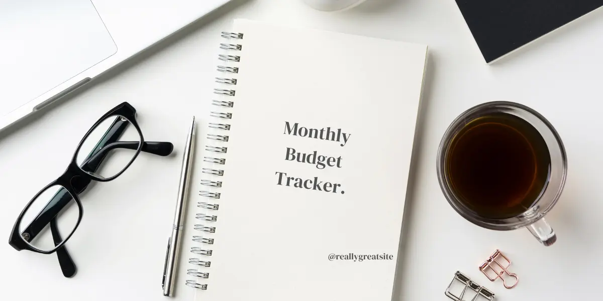 Flat lay of a colorful budget tracker notebook with handwritten expenses and planning tools — budgeting tips for families